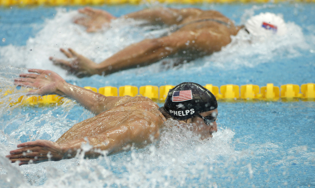 Image shows Team USA's Michael Phelps swimming against a competitor from Serbia in the 2008 Sumer Games in Beijing.