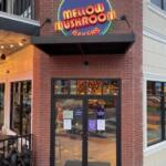 A brick store facade with a Mellow Mushroom neon sign.