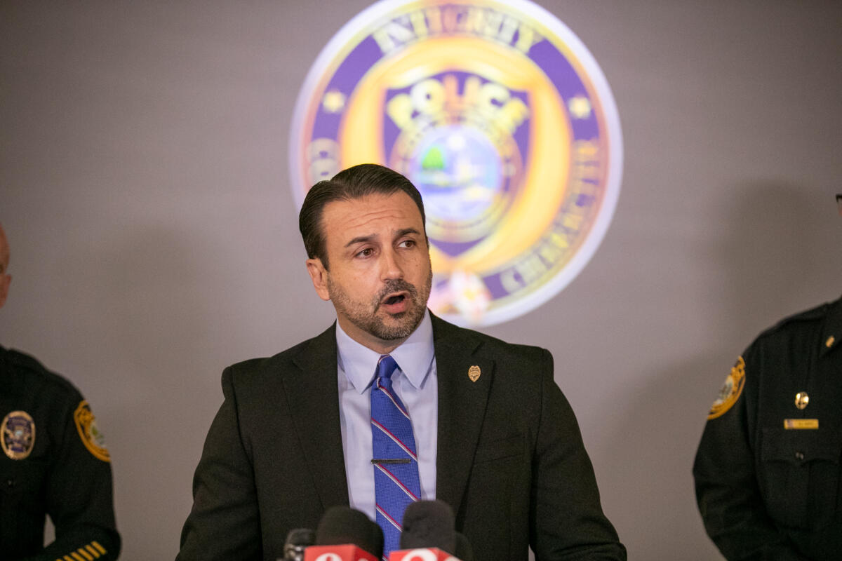 Mayor Ben Marciano speaks at a press conference with Ocala Police Department officials in front of a police emblem.