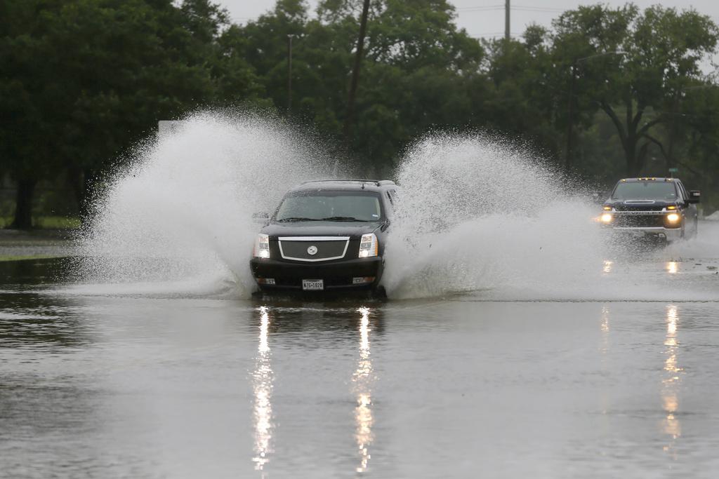 A car plows through floodwaters in Texas from Hurricane Beryl.