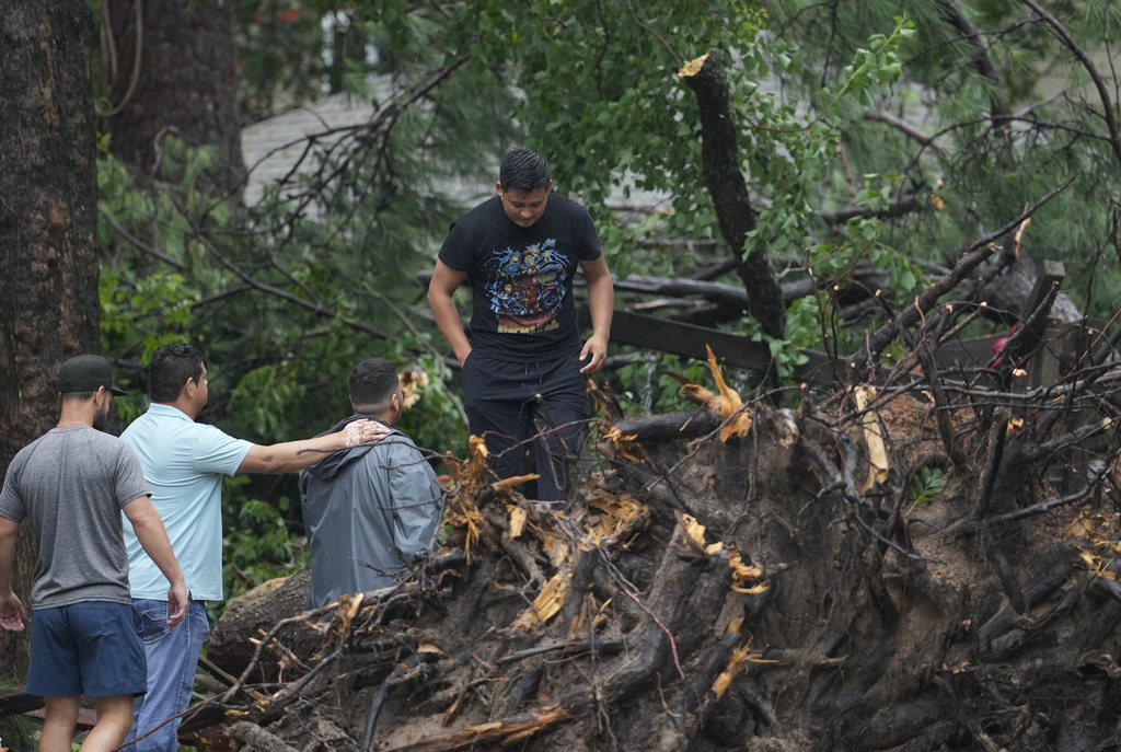 Men climb over debris left behind from Hurricane Beryl in Texas.