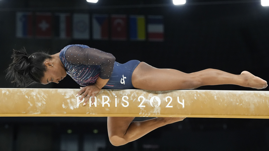 Image shows gymnast Simone Biles practicing on the balance beam in Paris, France.