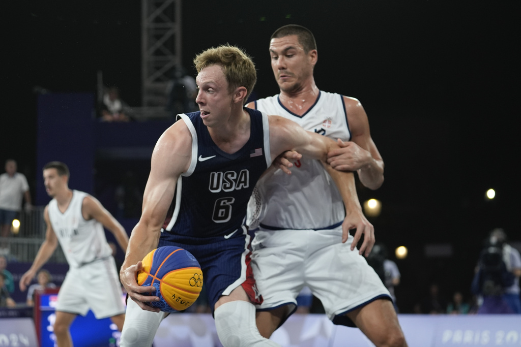 University of Florida graduate, Canyon Barry, fends off a player from Serbia in the men's 3x3 basketball pool round match at the 2024 Summer Olympics.