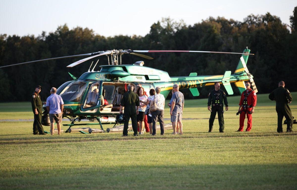 Image shows citizens gathered around the Marion County Sheriff's Office helicopter and pilots speaking with them.