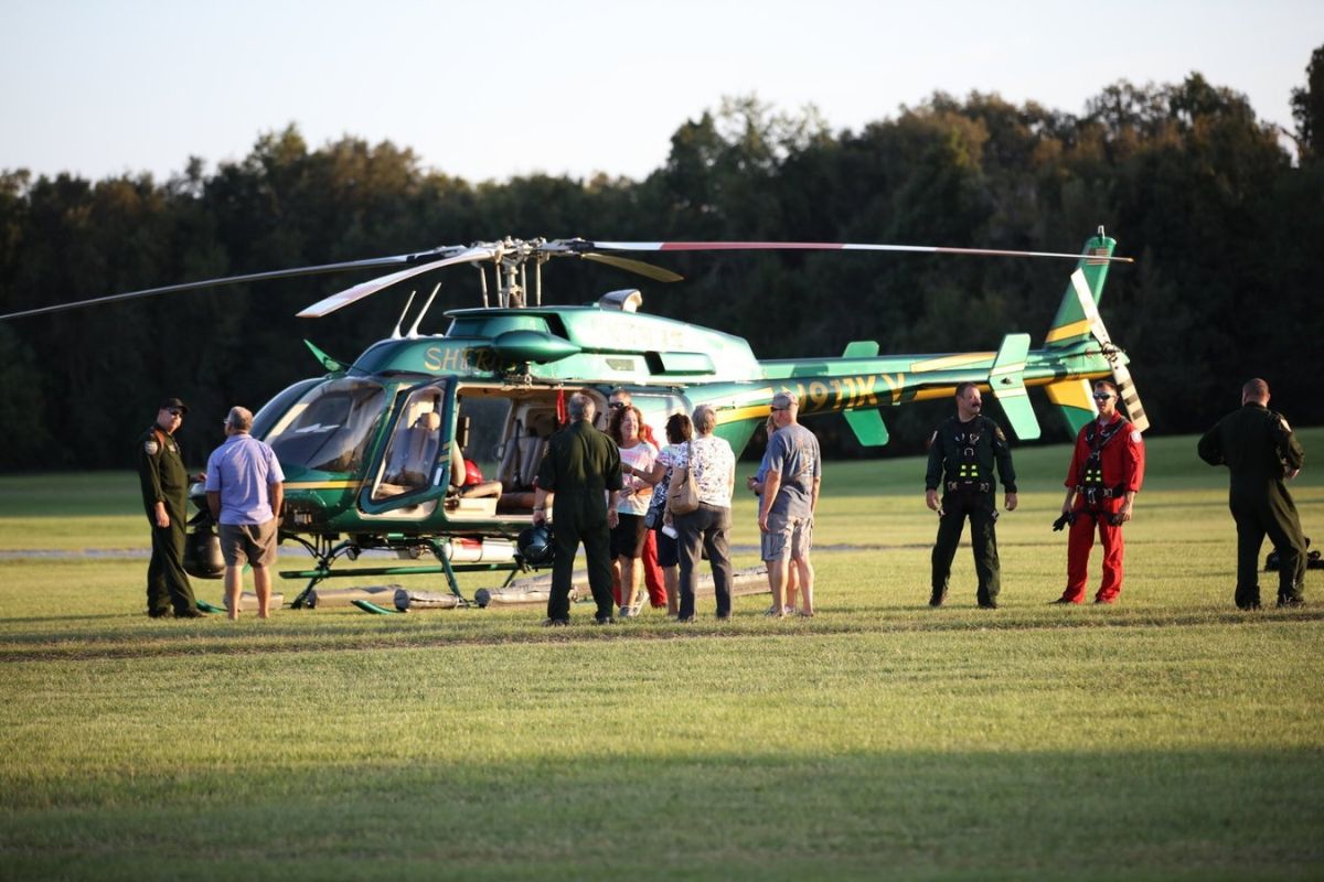 Image shows citizens gathered around the Marion County Sheriff's Office helicopter and pilots speaking with them.