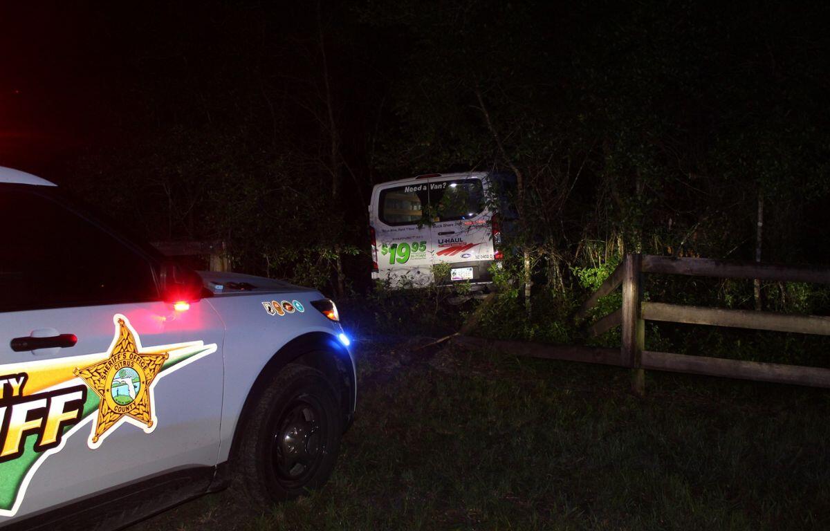 Image shows Citrus County Sheriff's deputy's patrol car behind a U-Haul van that was crashed through a fence and into a tree.