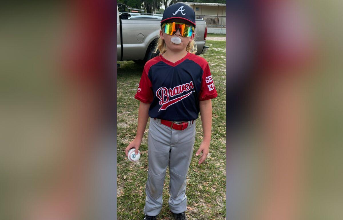 Photo of Jack Keuntjes suited up for a baseball game with his mullet tucked beneath his ball cap.