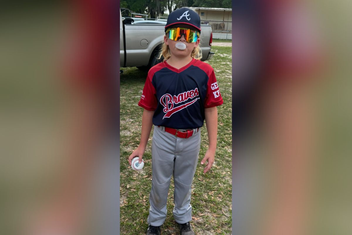 Photo of Jack Keuntjes suited up for a baseball game with his mullet tucked beneath his ball cap.