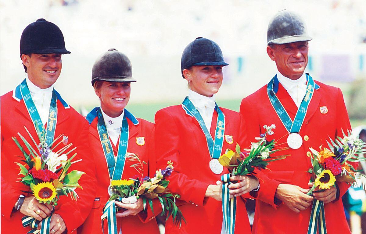 Photo shows Ocala's Jill Henneberg (center right) with fellow Team USA eventing riders David O’Connor (left), Karen O’Connor (center left), and Bruce Davidson (right) on the podium in Atlanta with their silver medals.