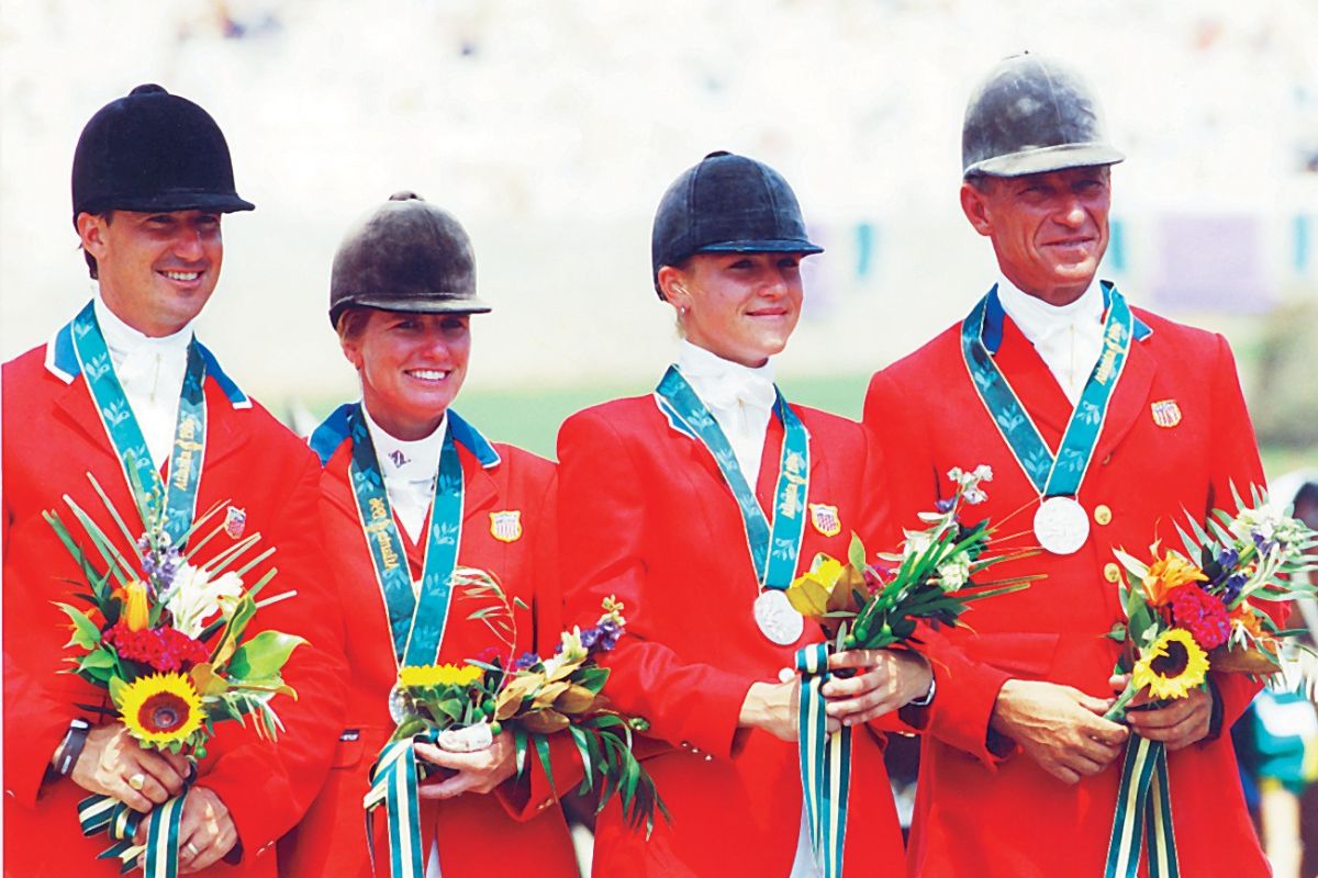 Photo shows Ocala's Jill Henneberg (center right) with fellow Team USA eventing riders David O’Connor (left), Karen O’Connor (center left), and Bruce Davidson (right) on the podium in Atlanta with their silver medals.