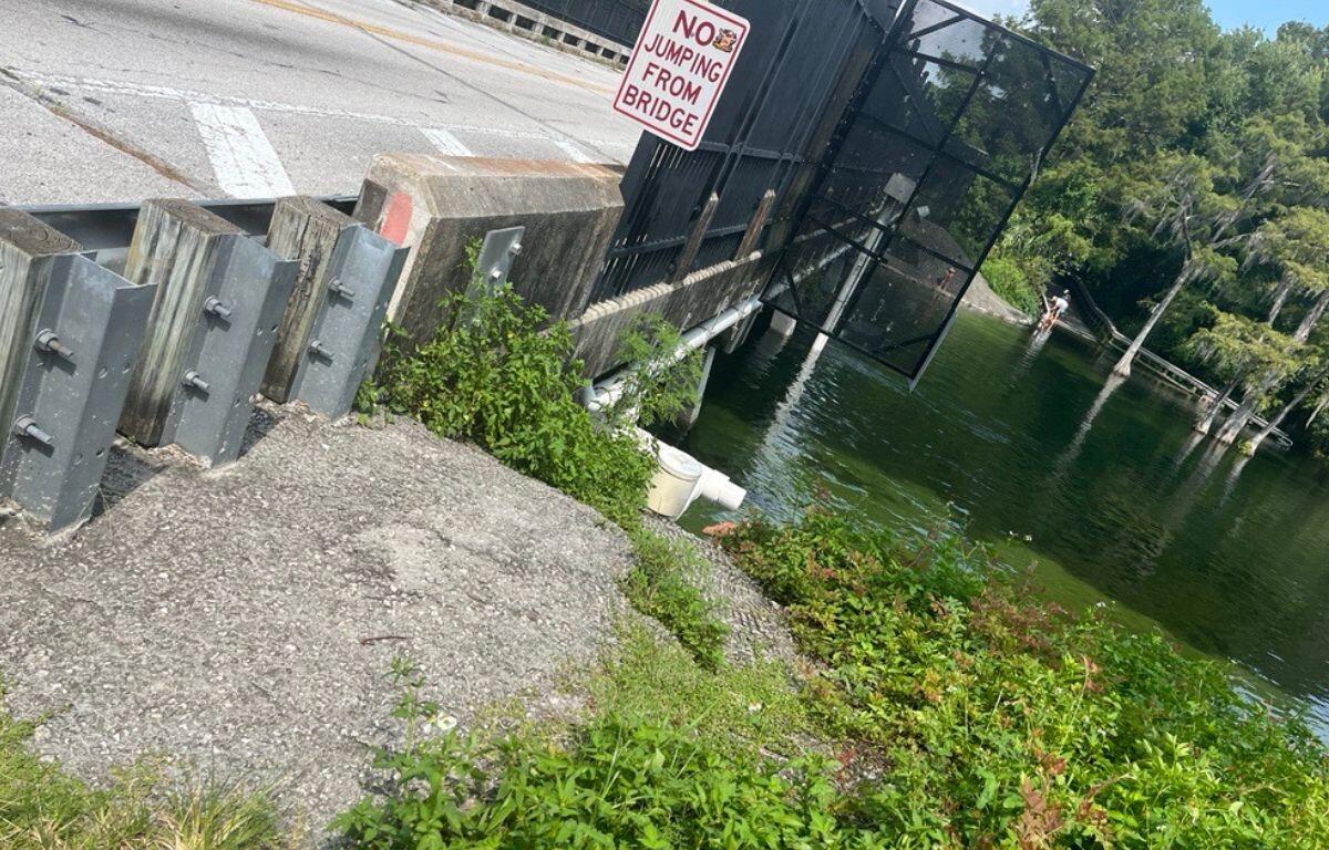 Image of the County Road 484 bridge and the stormwater pipes that people hang off of and jump into the water below.
