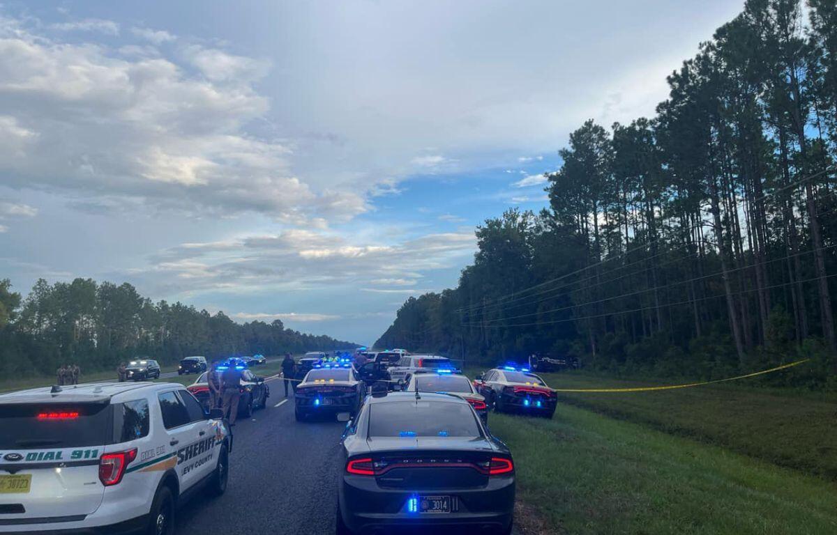 Image shows more than a dozen law enforcement officers blocking U.S. Highway 19.