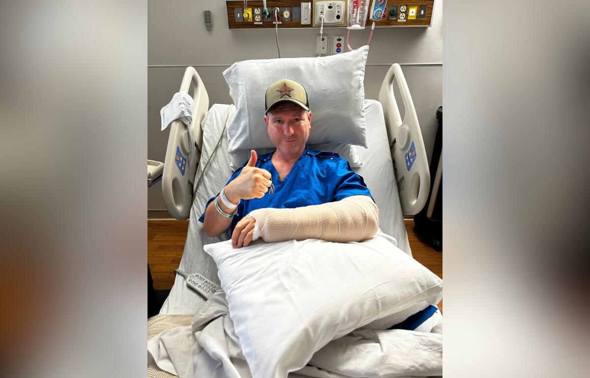 Image of Lake County, FL Master Deputy Harold Howell in hospital bed giving thumbs up after surgery.