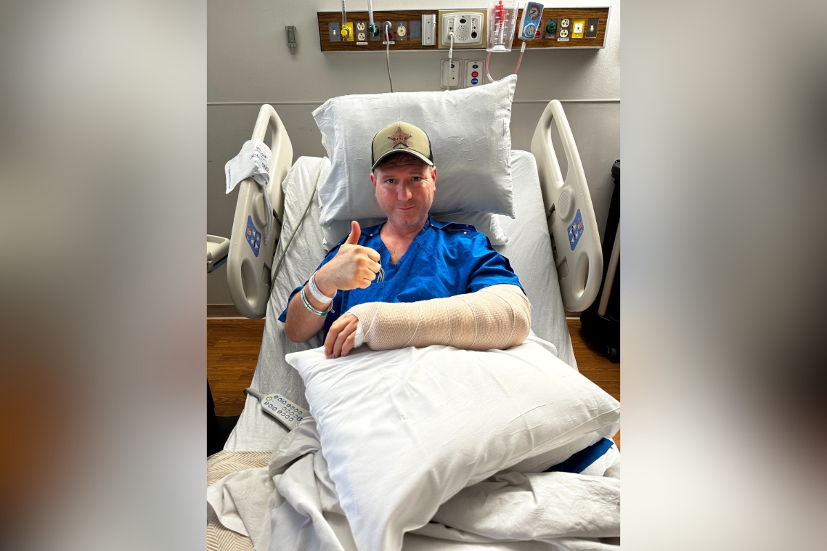 Image of Lake County, FL Master Deputy Harold Howell in hospital bed giving thumbs up after surgery.