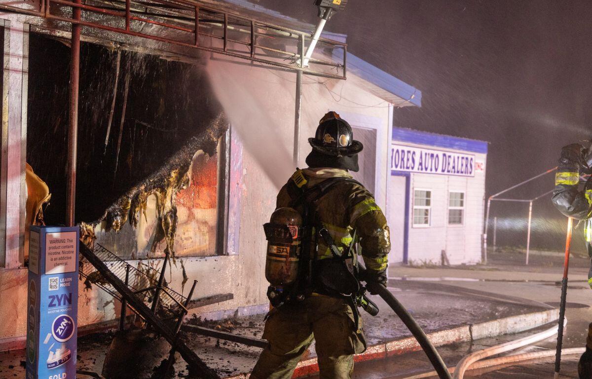 Photo shows firefighters extinguishing the convenience store blaze.