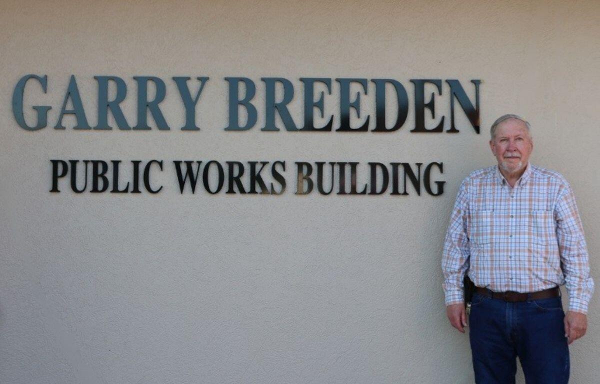 Garry Breeden stands alongside the Public Works Building which now bears his name.