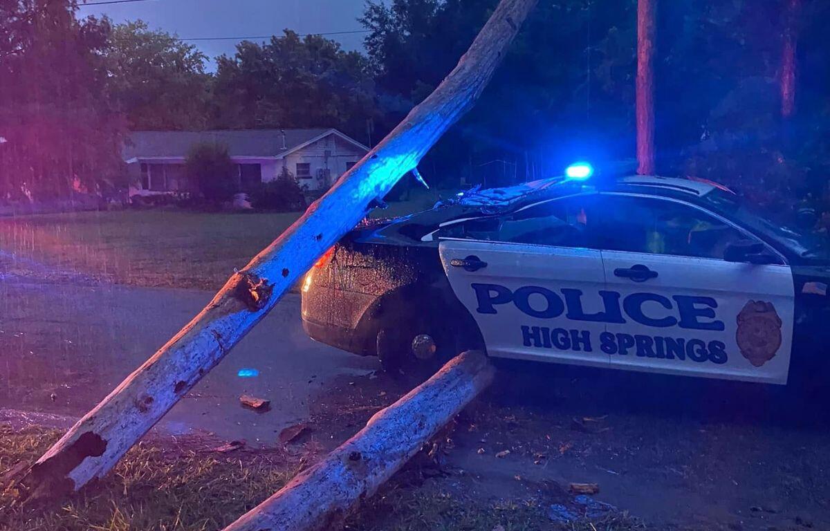 Image shows trees down around a High Springs Police Department cruiser.
