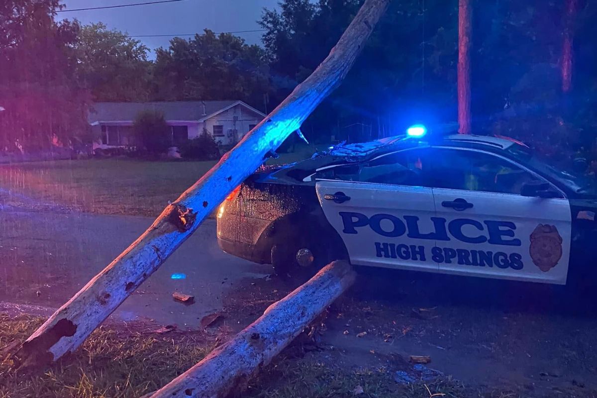 Image shows trees down around a High Springs Police Department cruiser.
