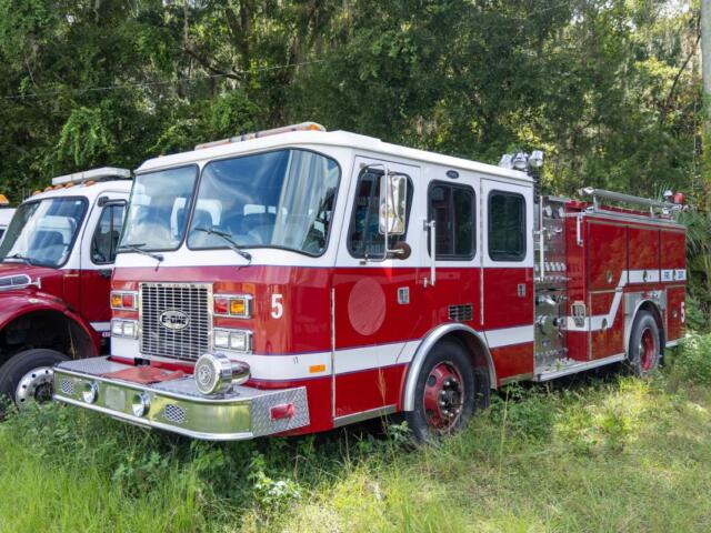 Marion County fire engine parked in grass near wooded area