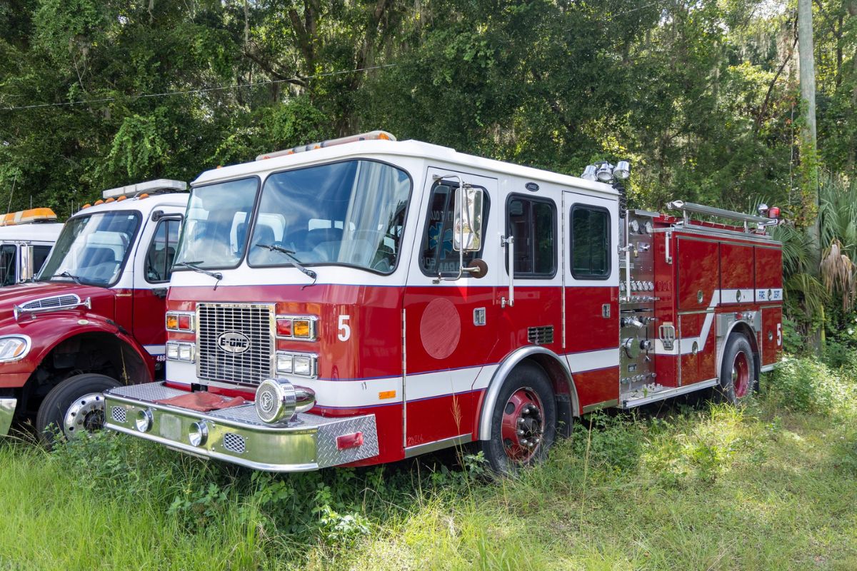 Marion County fire engine parked in grass near wooded area