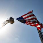 Flag flying between ladders in sunshine blue sky