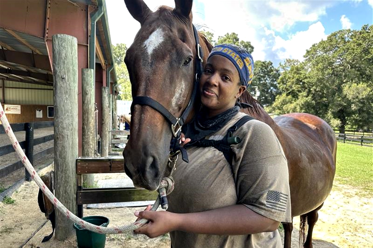 Kira Zeynalov, a U.S. Navy veteran managing PTSD and MS, shares a tender moment with Rowdy, one of the therapy horses at the Marion Therapeutic Riding Association in Ocala.