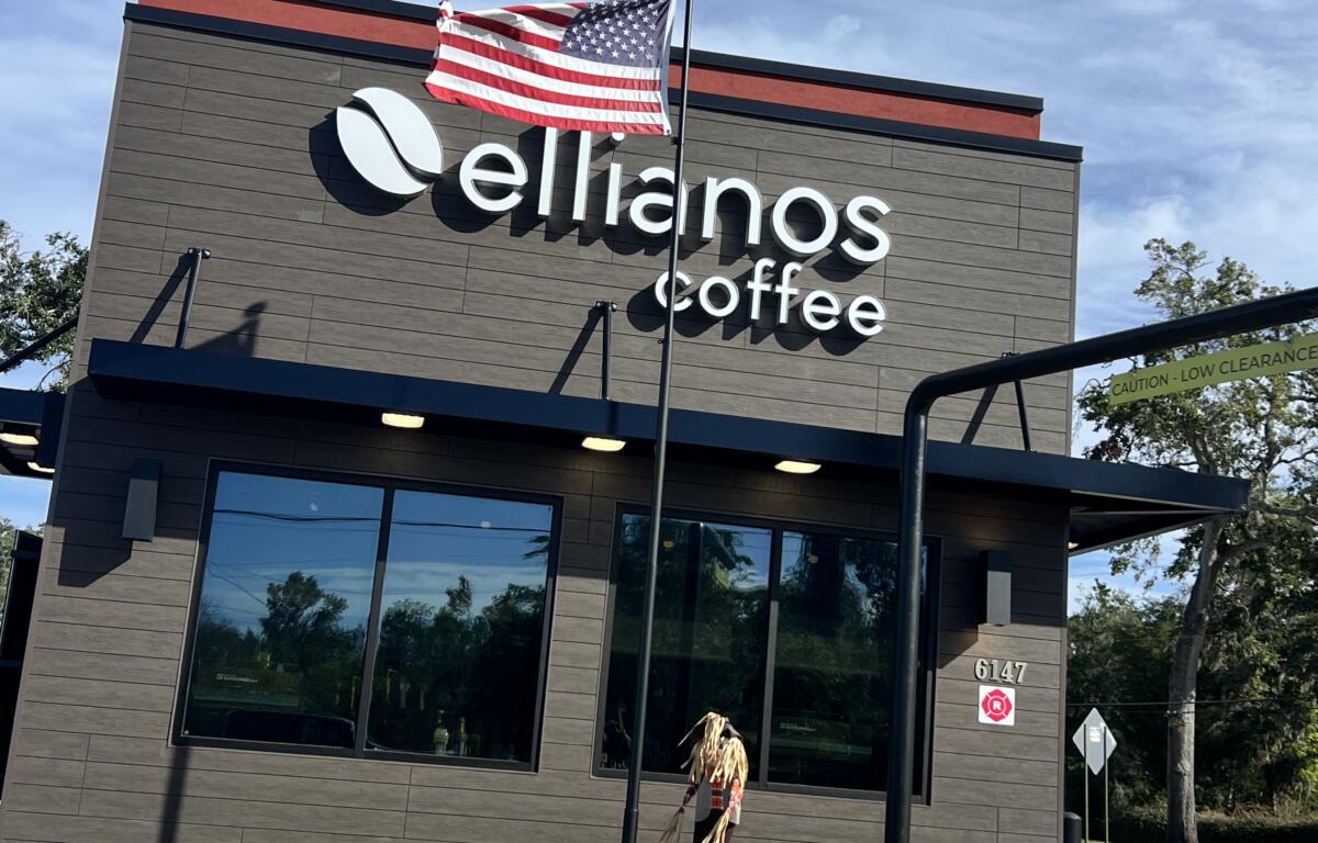 Ellianos Coffee decorates exterior of building with festive flowers and scare crow decorations.