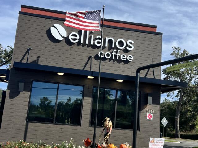 Ellianos Coffee decorates exterior of building with festive flowers and scare crow decorations.