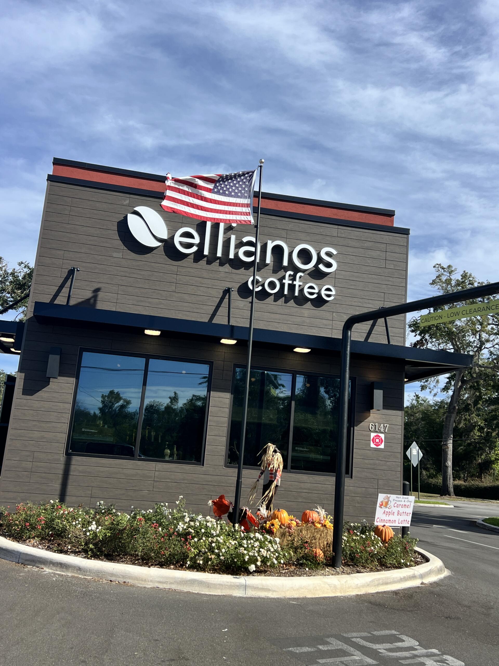 Ellianos Coffee decorates exterior of building with festive flowers and scare crow decorations.