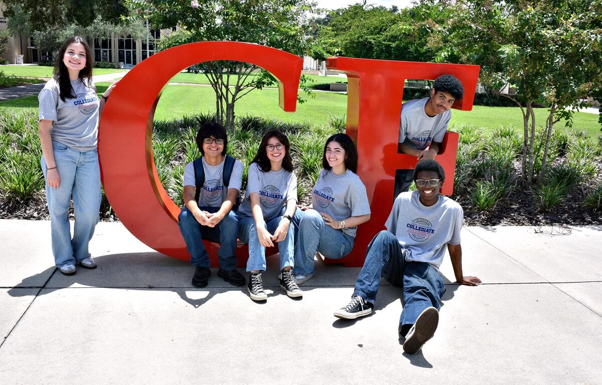 Group of College of Central Florida students sitting and standing around large red "CF" letters on campus.