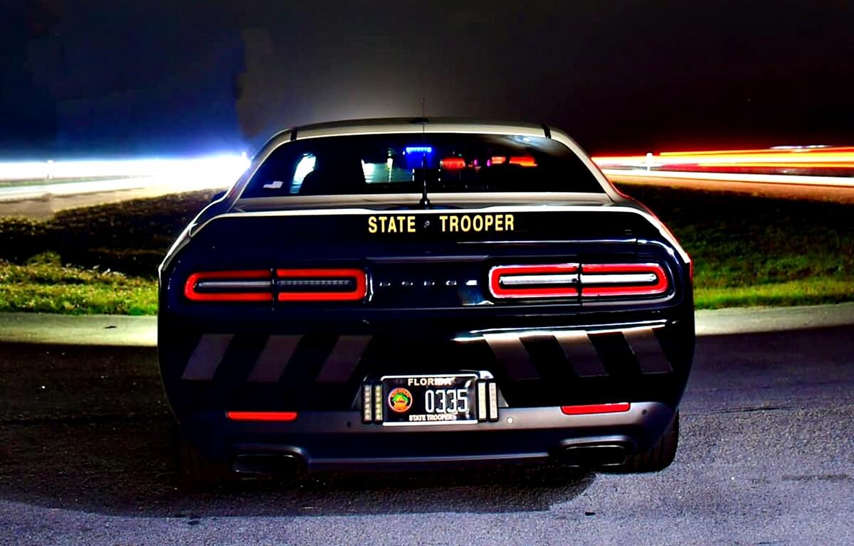Florida Highway Patrol cruiser parked at night with emergency lights on