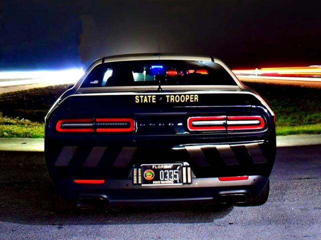 Florida Highway Patrol cruiser parked at night with emergency lights on