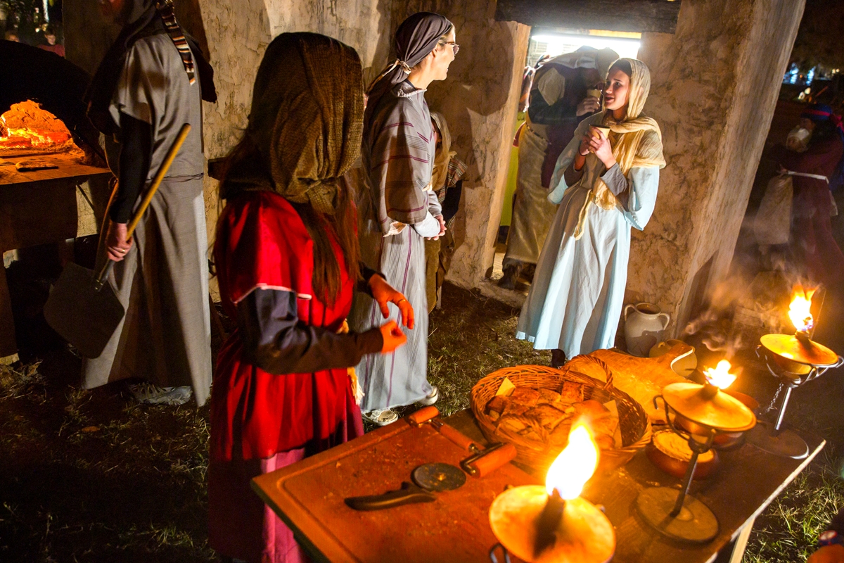 Cast members make bread as thousands traveled through the live history of Christianity and spent a moment with the Baby Jesus during the 29th Annual Good Shepherd Presbyterian Living Nativity Pageant. Sunday, Dec. 22, 2024, in Ocala, Fla.