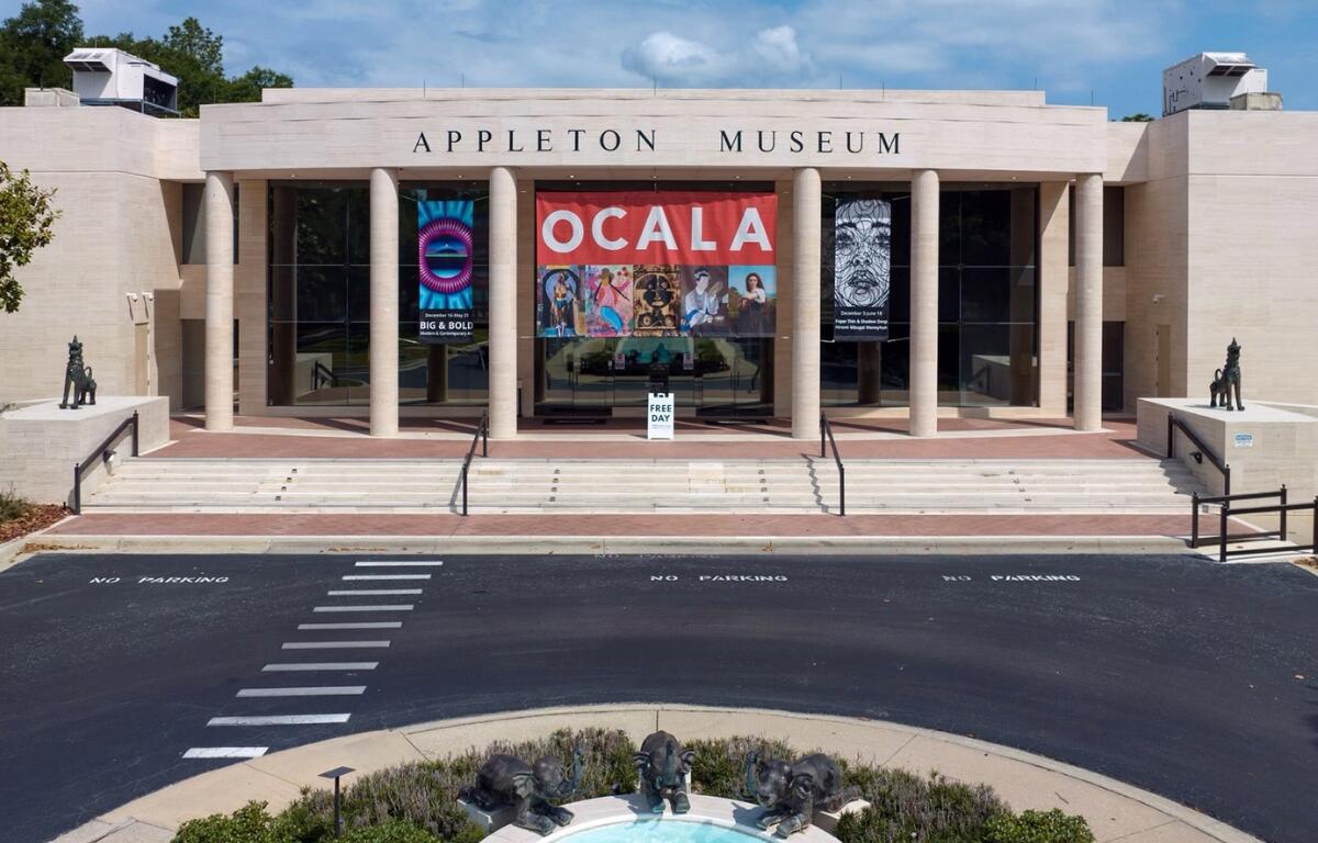 Front view of the Appleton Museum of Art in Ocala with event banners and fountain in foreground.