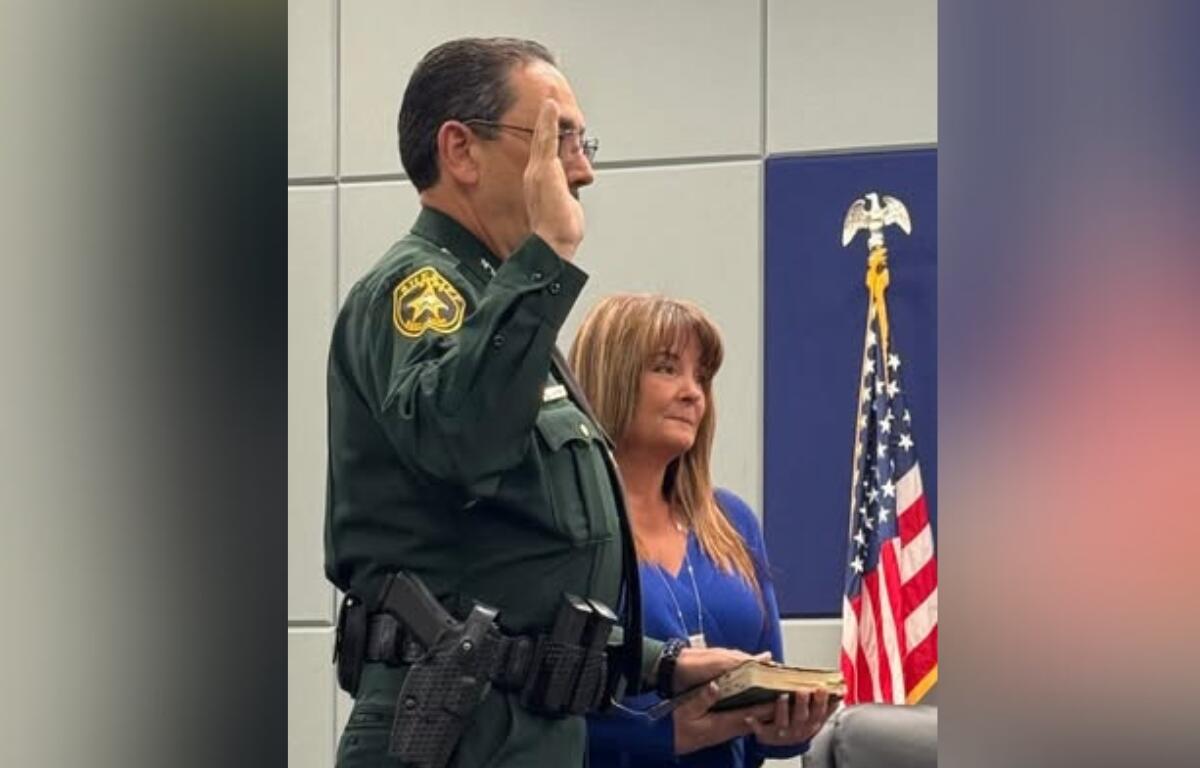 Sheriff Billy Woods takes the Oath of Office for his third term, administered by Judge Timothy McCourt, during a ceremony on Tuesday morning.