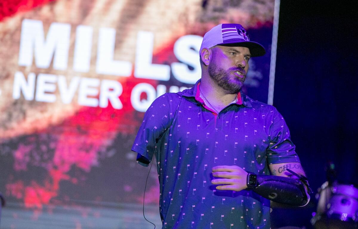 Travis Mills shares his life story during the Never Give Up on Country benefit concert at Sheltair at the Ocala International Airport on Jan. 31, 2025. The event supports wounded veterans through the Travis Mills Foundation.