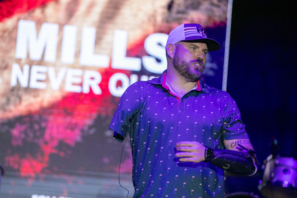 Travis Mills shares his life story during the Never Give Up on Country benefit concert at Sheltair at the Ocala International Airport on Jan. 31, 2025. The event supports wounded veterans through the Travis Mills Foundation.