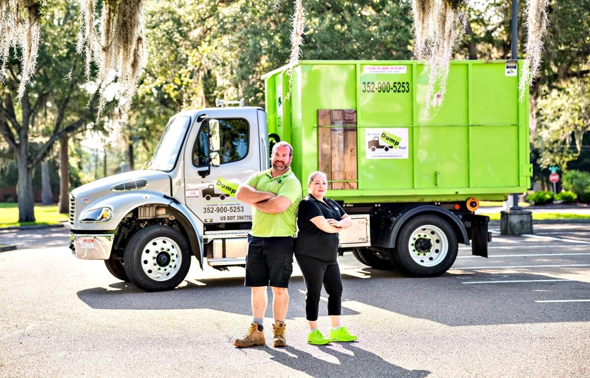 Ryan Smith and Sarah Karremans, owners of Bin There Dump That Residential Friendly Dumpsters, pose in front of one of their trucks. The locally owned company provides dumpster rental services to residential and commercial customers in the Ocala, Belleview, and Gainesville areas.