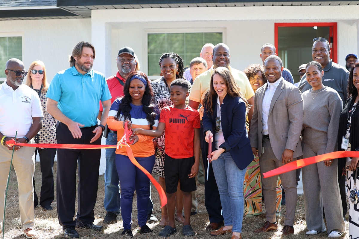 Crystal Canfall and her family, joined by representatives from the City of Ocala and D & S Development, cut the ribbon on their new home, the first completed under the city's Affordable Housing Initiative, during a ceremony in Ocala, FL on Feb. 5, 2025. The initiative aims to address housing needs by utilizing surplus city land.