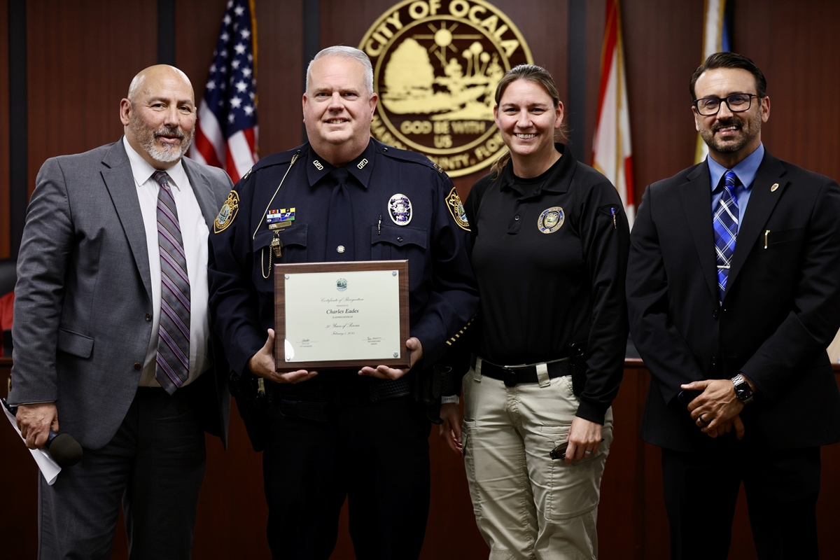 Ocala Police Capt. Charlie Eades receives a certificate recognizing his 30 years of service during Tuesday night's City Council meeting.