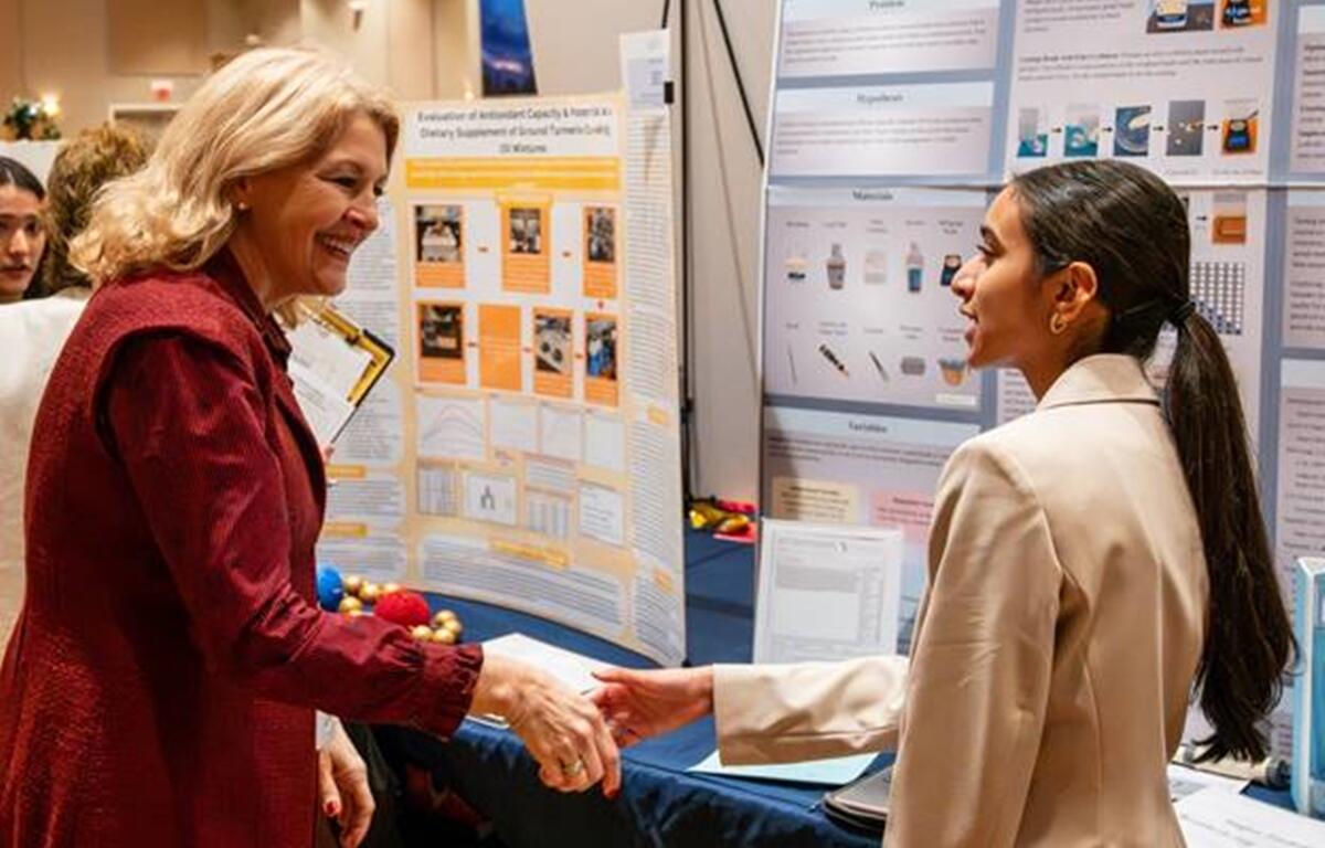 Dr. Diane Gullett, MCPS Superintendent, shakes hands with Megha Sandrapaty, Forest High School, during the Big Springs Regional STEM Fair.
