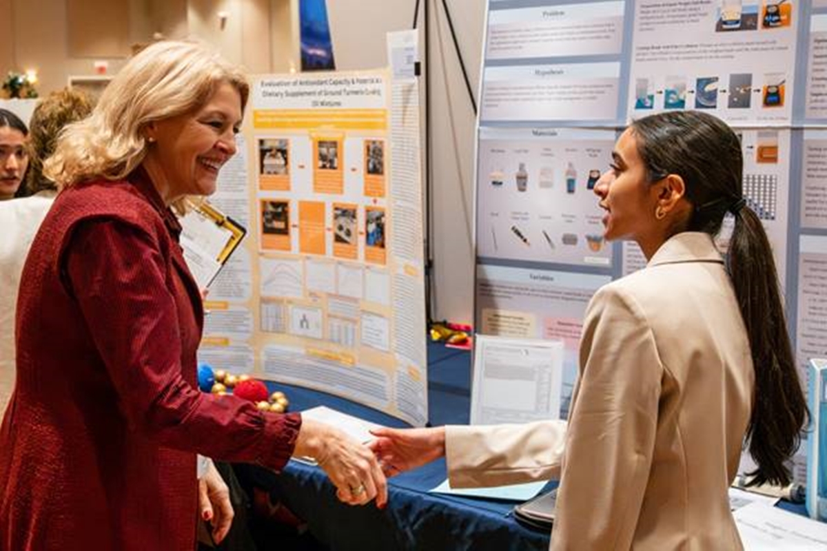 Dr. Diane Gullett, MCPS Superintendent, shakes hands with Megha Sandrapaty, Forest High School, during the Big Springs Regional STEM Fair.