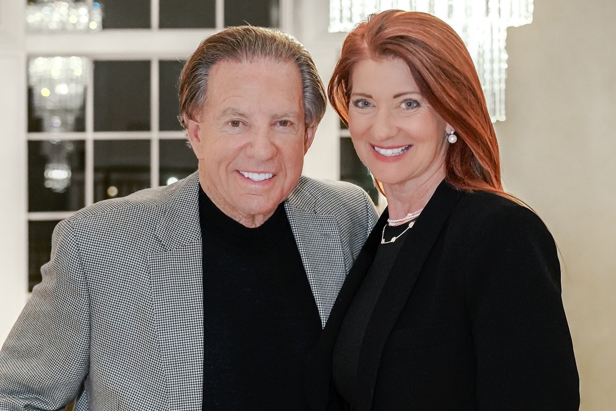 Frank and Angela DeLuca smiling and standing side by side indoors.