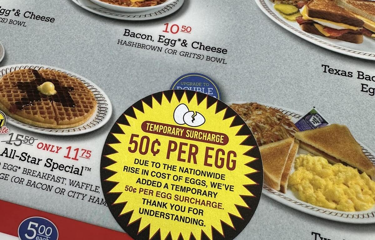 A Waffle House menu in Ocala, Florida, displays a 50-cent egg surcharge sticker as rising egg prices impact restaurant costs.