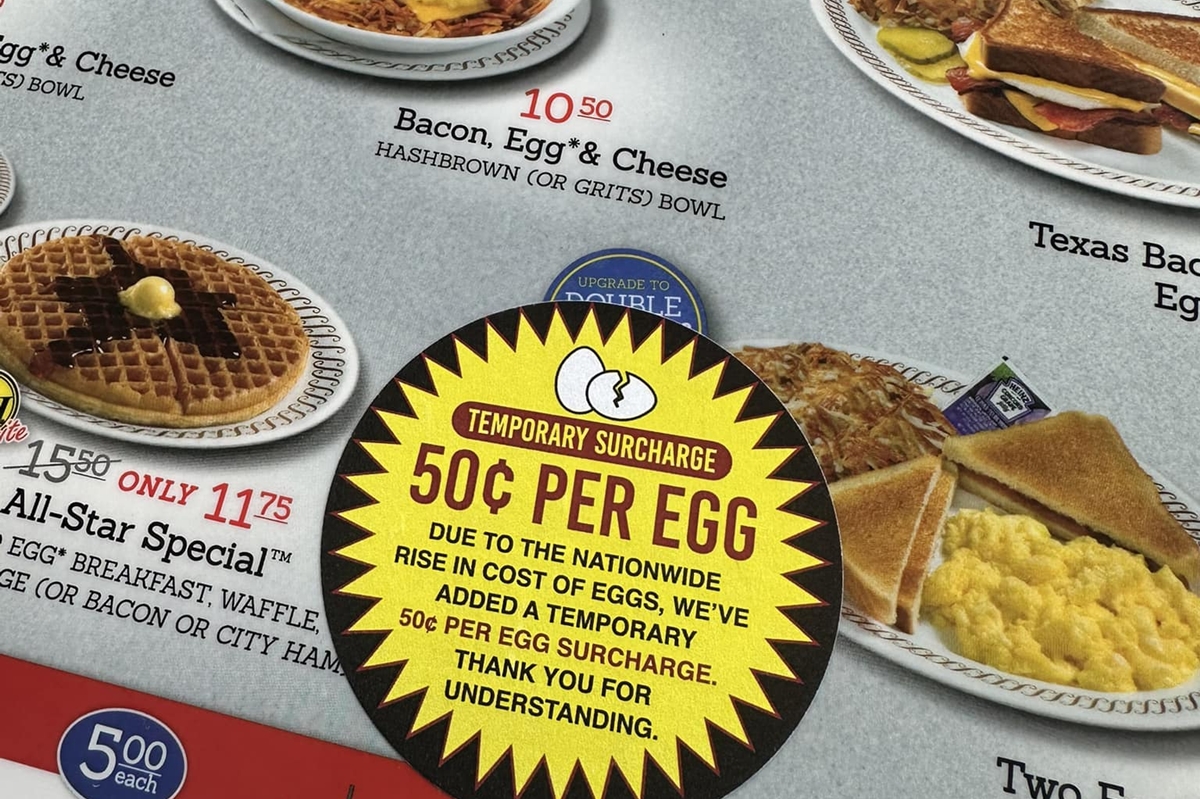 A Waffle House menu in Ocala, Florida, displays a 50-cent egg surcharge sticker as rising egg prices impact restaurant costs.