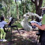 Campers at the Appleton Museum of Art’s Summer Art Camp paint outdoors during an en plein air session, capturing nature’s beauty on canvas.