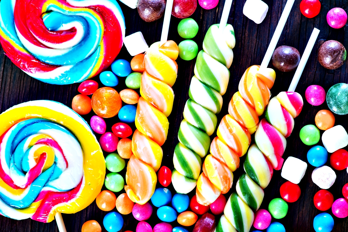 Colorful swirls of lollipops and assorted candies create a vibrant, whimsical display, evoking the playful world of Willy Wonka.