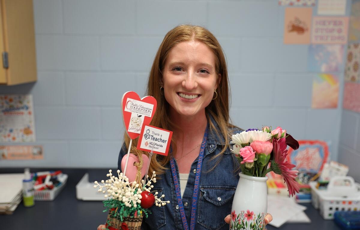 Claire Sensibaugh, a geometry teacher at Vanguard High School, holds gifts presented to her after receiving the “Thank a Teacher” award in Ocala, Fla., on March 25, 2025.