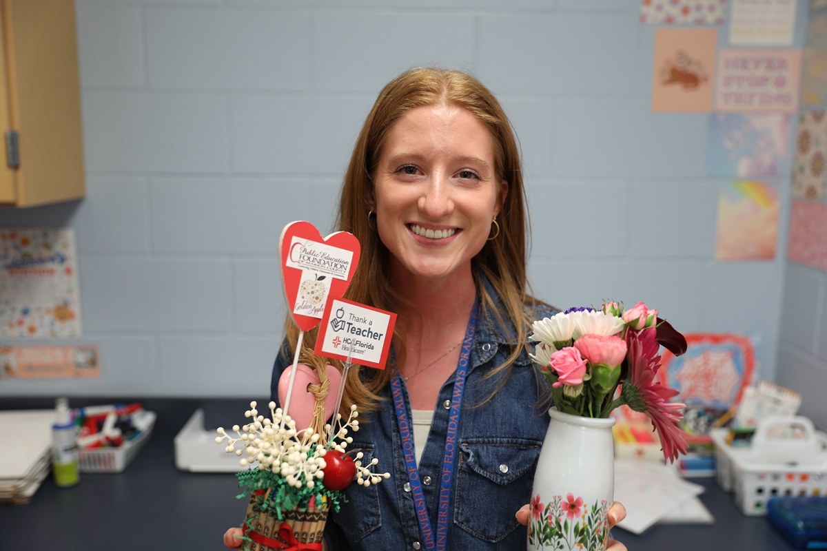 Claire Sensibaugh, a geometry teacher at Vanguard High School, holds gifts presented to her after receiving the “Thank a Teacher” award in Ocala, Fla., on March 25, 2025.