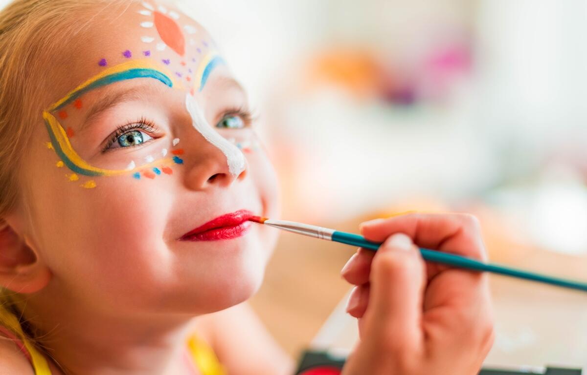 A child gets her face painted during a family event.